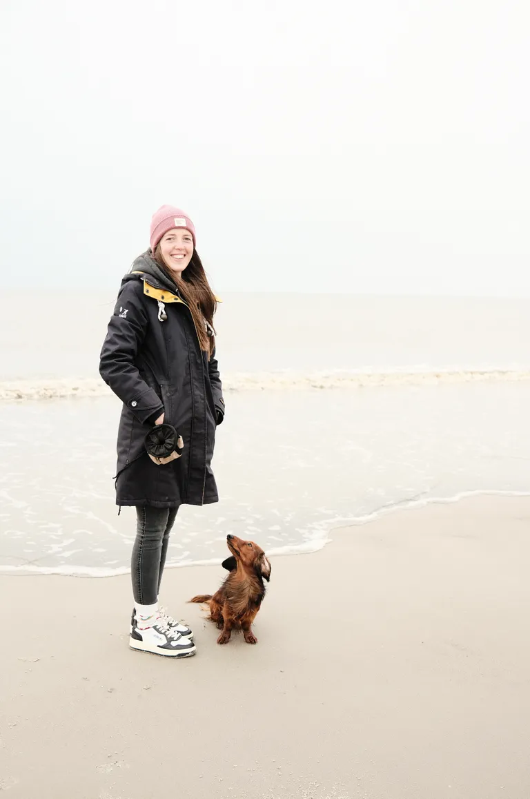 Anna Schmalenstroer am Strand mit ihrem langhaarigen Dackel, der zu ihr aufblickt
